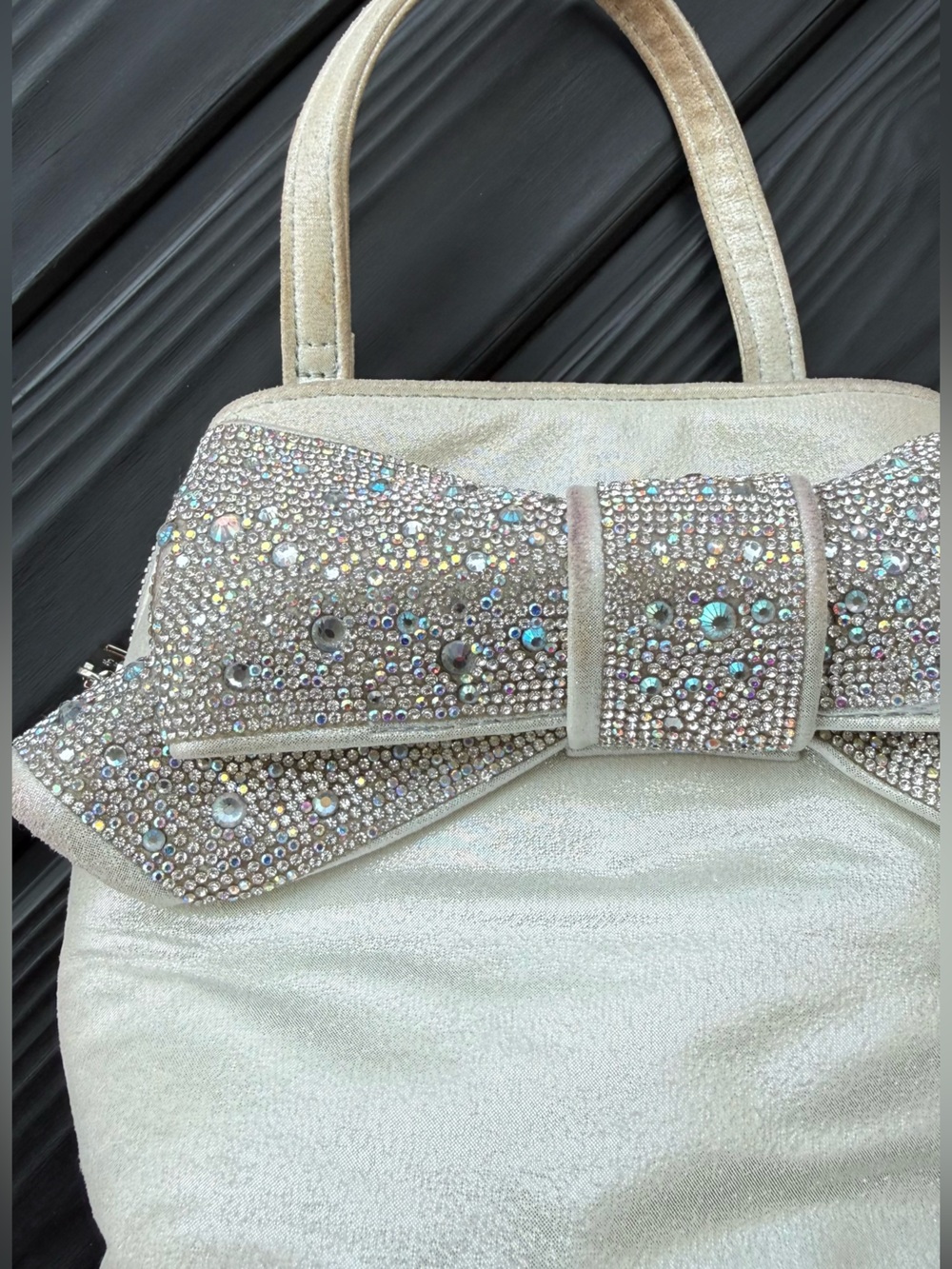 Betsey Johnson Sparkling Bow Iridescent Cream w/Pink Interior Handheld